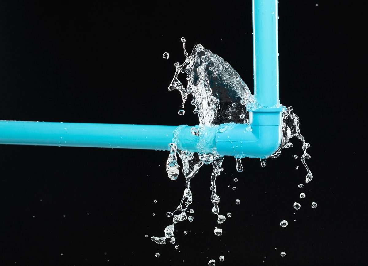 Water leaking from a blue plastic PVC pipe