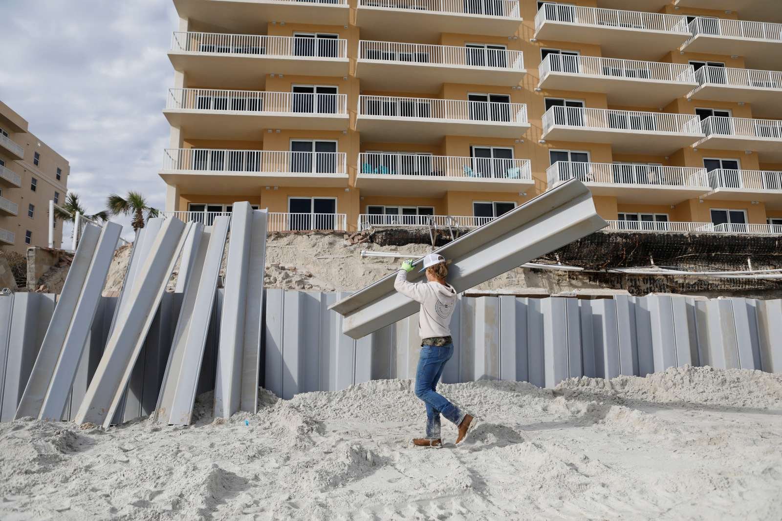 Photo of a seawall being constructed on a beach in front of a condo