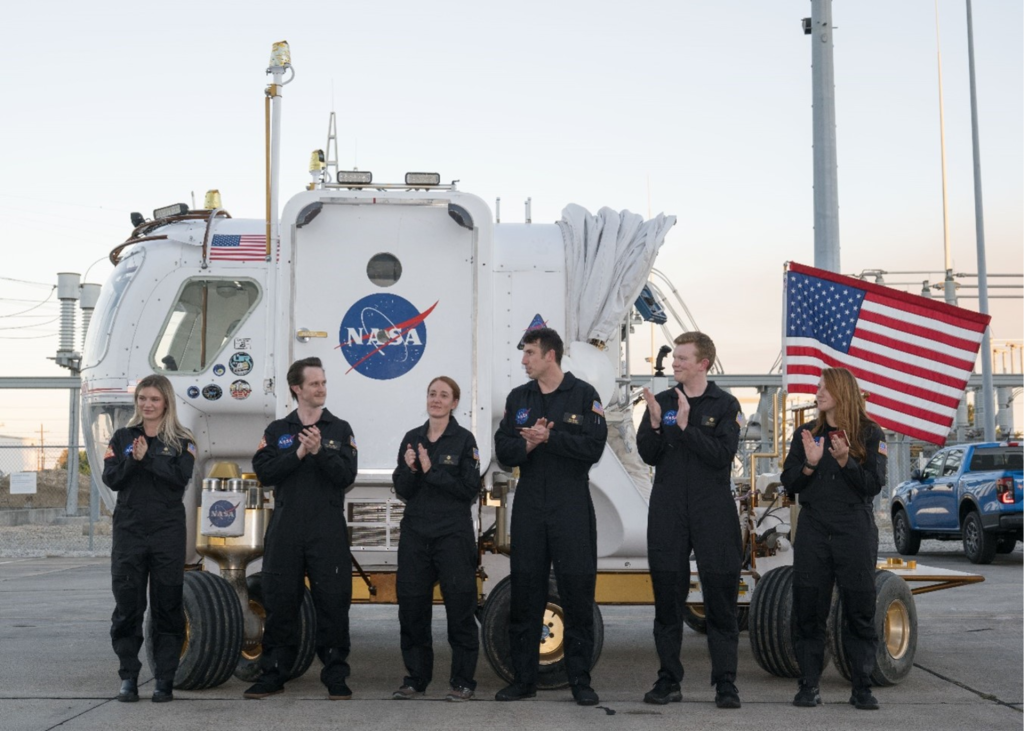 The CHAPEA mission 2 main crew and two alternate crew members are pictured in front of the Space Exploration Vehicle, the prototype pressurized rover that transported crew members to the habitat at the start of the mission.