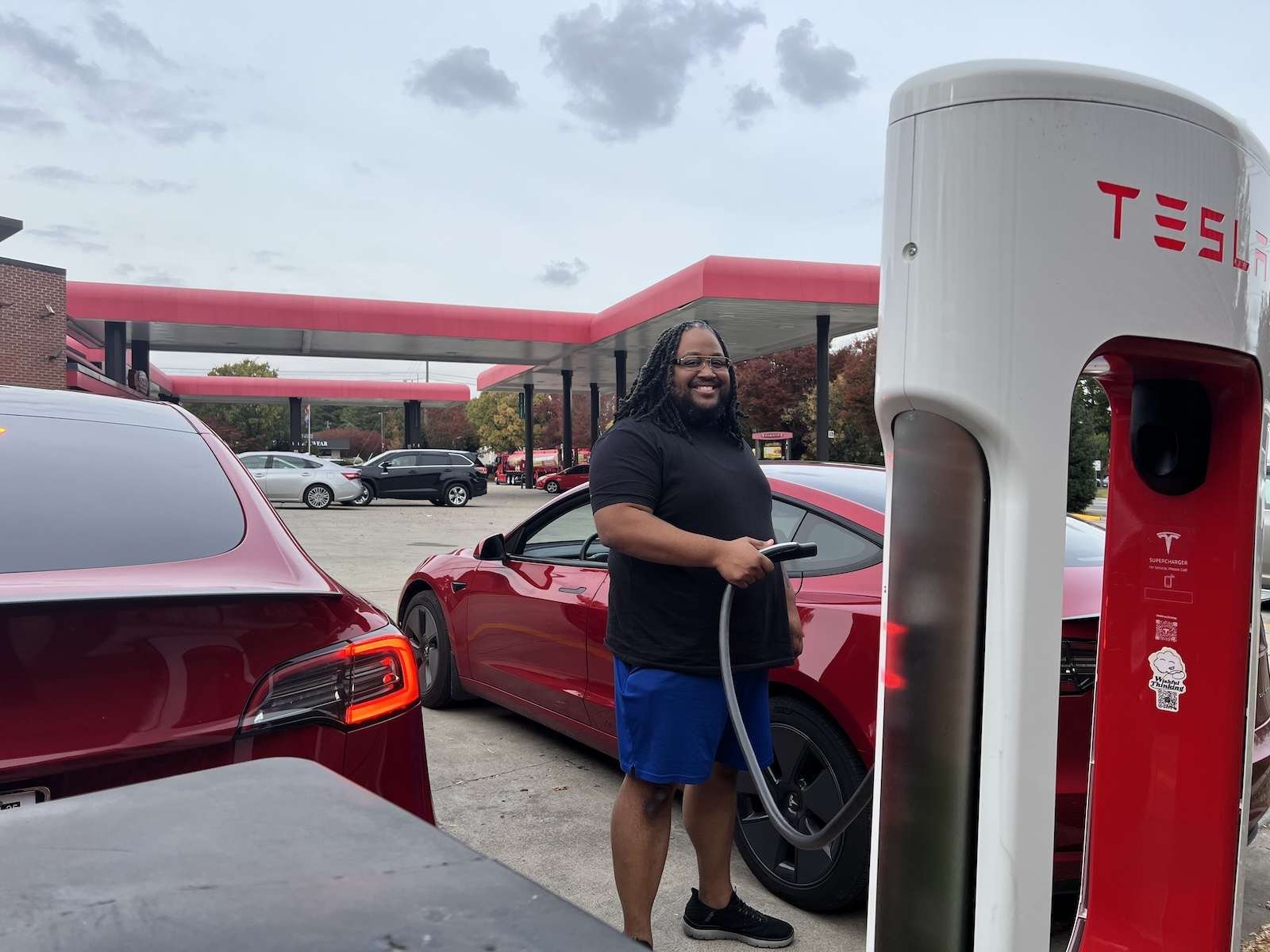 A man charges his Tesla model 3 at a charging station at a Sheetz convenience store