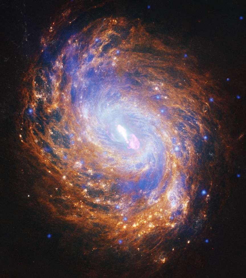 A gold and blue spiral galaxy swirls in the darkness of space. There is a bright spot of light at its center.