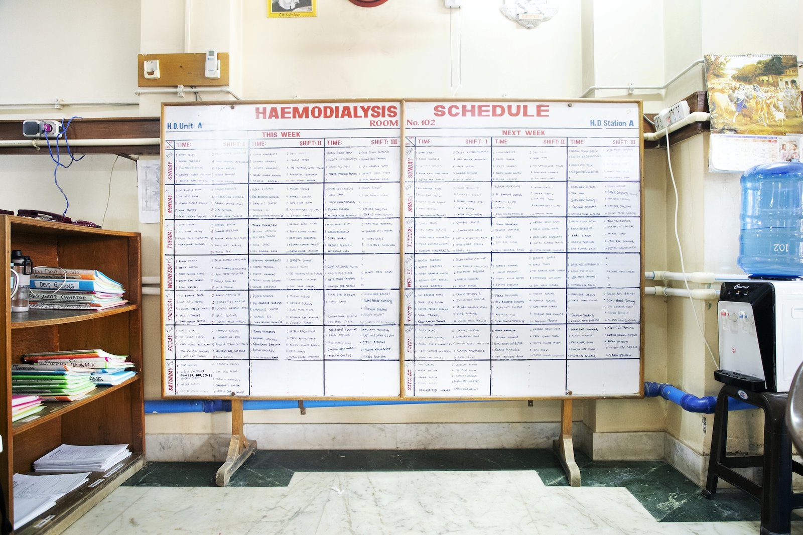 a white board with a char structure showing times and patient names in a hospital setting