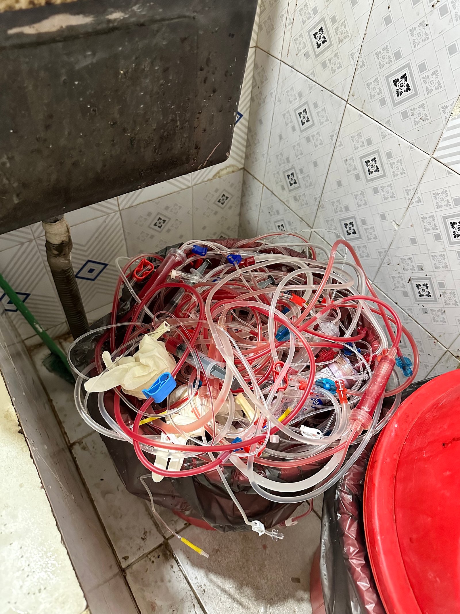 tubes filled with blood in a trash can