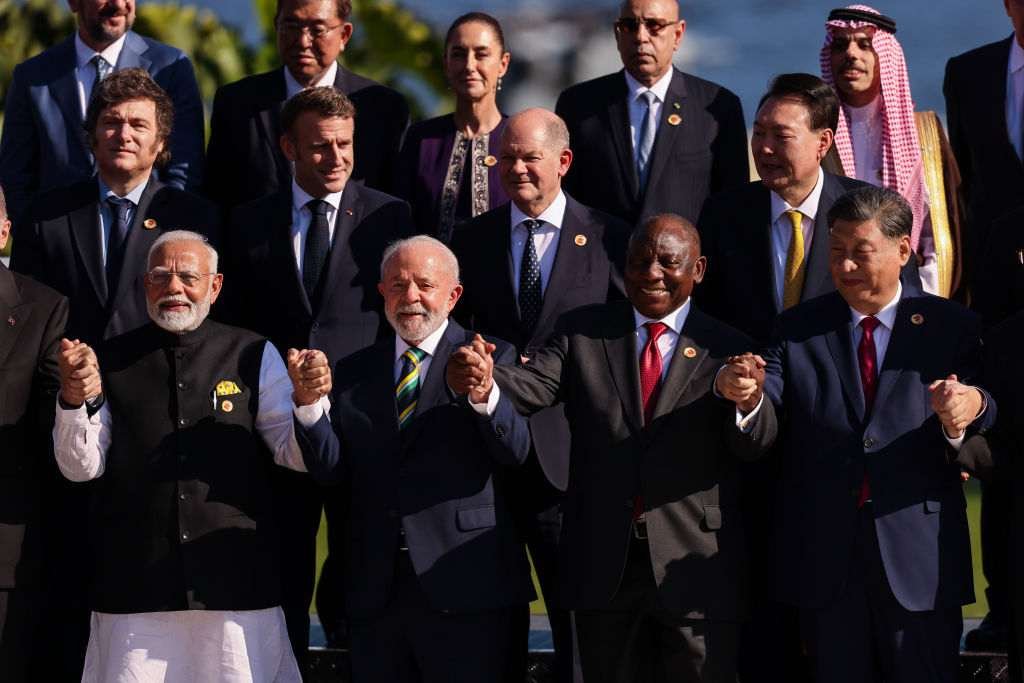 Presidents of various countries stand holding hands