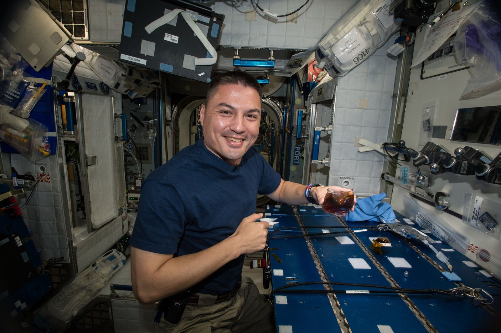 A man drinks a cup of coffee aboard the space station.