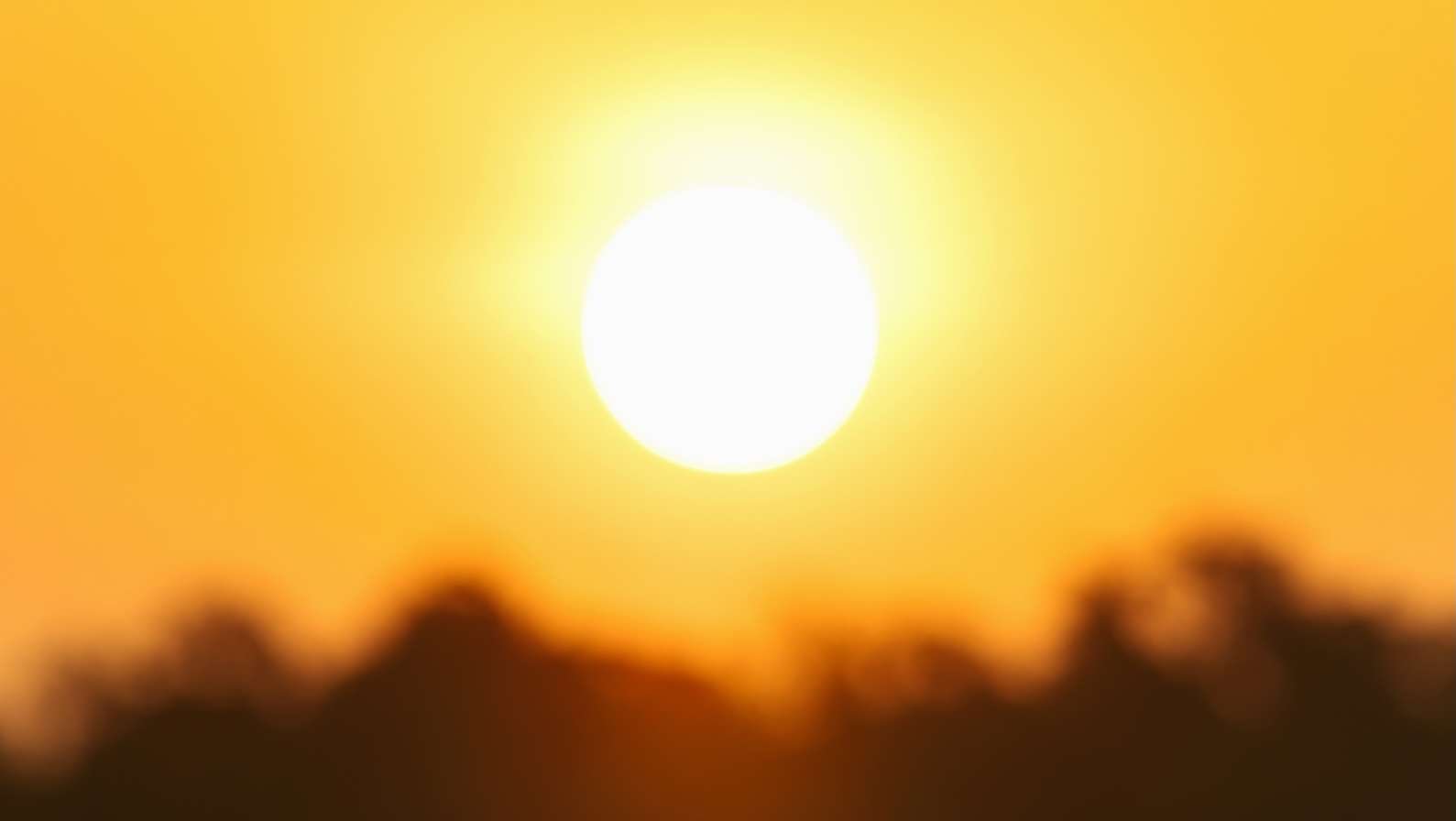 a hot sun with heat blur over a landscape also blurred