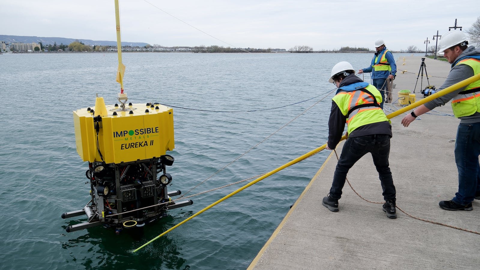 Impossible Metals workers help positioning the Eureka II, a robotic underwater vehicle while lifting up from the water in Collingwood, Ontario, on May 1, 2025.