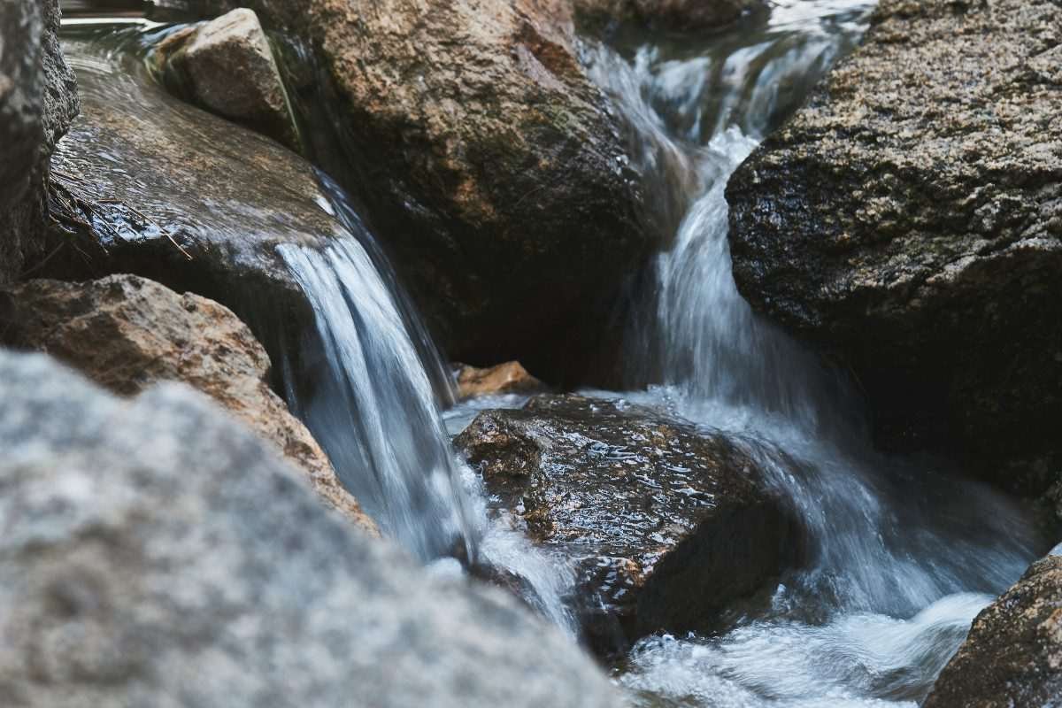 Close-up of rocks in an environment like a river, with clear, translucent water passing over these surfaces