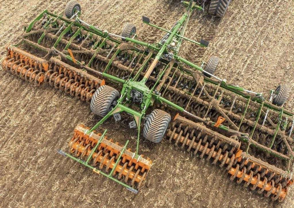 View from above of a green and orange Amazone fertilizer in the field.