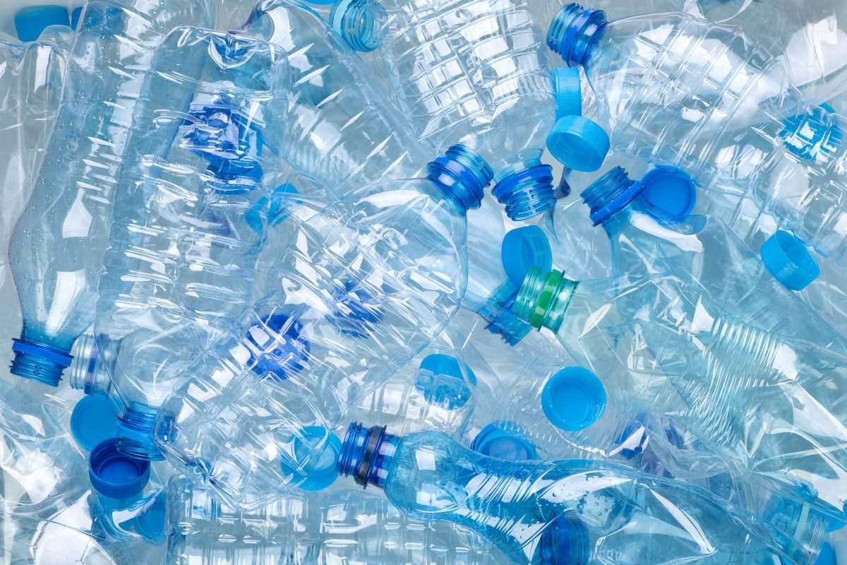 A mass of plastic bottles slightly pressed together, as though being stored in a haphazard way