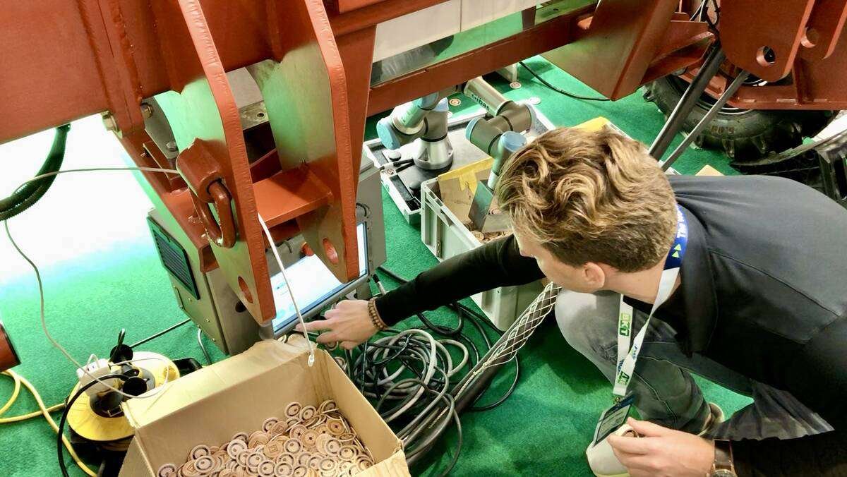 A Carbon Robotics’ team member sets up the LaserWeeder to burn small wood discs for a demonstration of the lasers at Agritechnica 2025.  Photos: Greg Berg