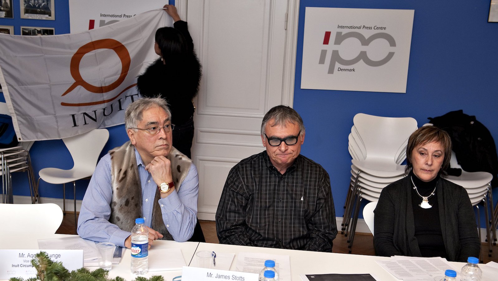 Aqqaluk Lynge, left, sits at a table and listens during a press conference on the Inuit Circumpolar Council on the effects of climate change in 2009.
