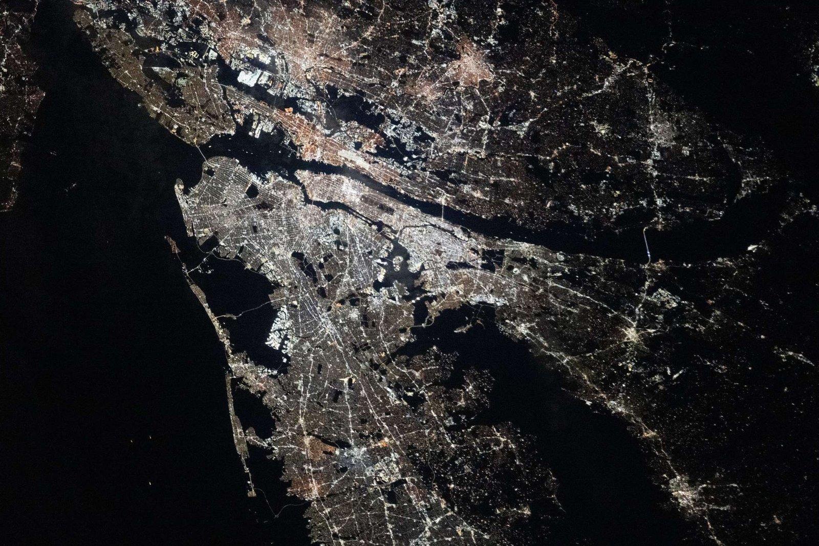 The New York–Newark–Jersey City Metropolitan Area at night. City lights illuminate most of the image.