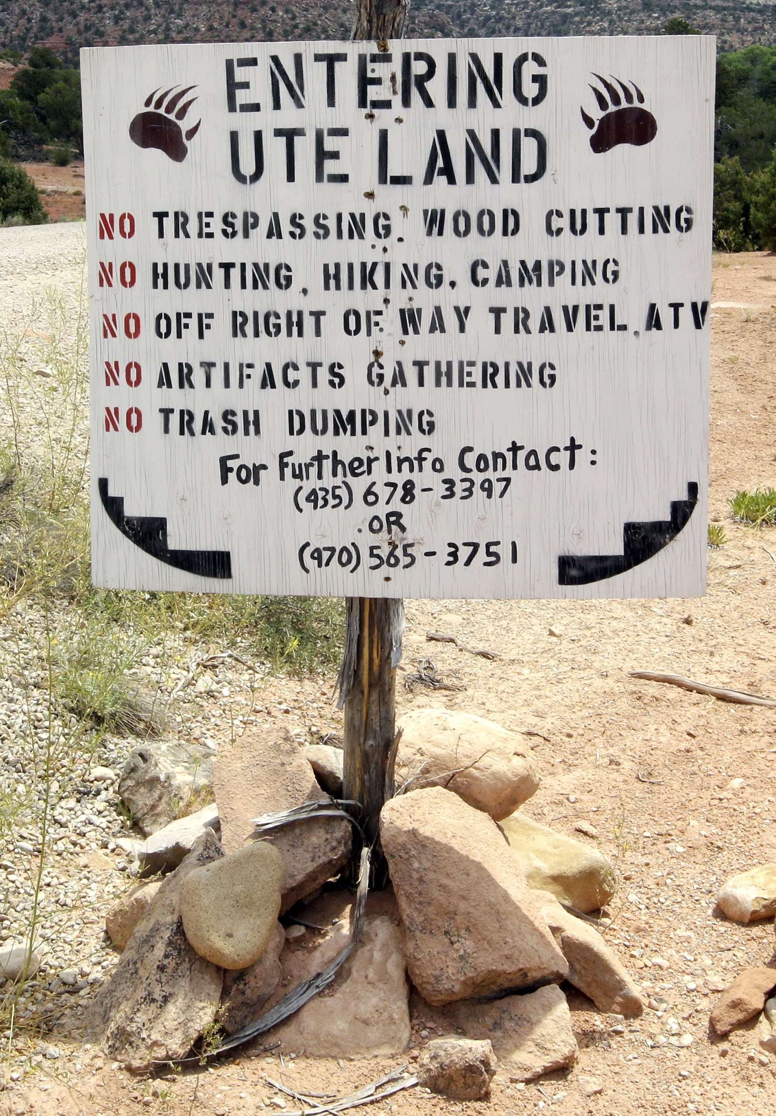 a sign that says 'entering ute land' with a list of rules and a phone number