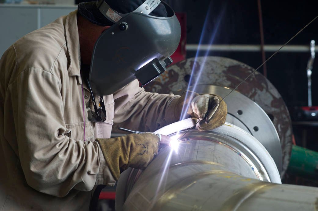 A welder at  works on a portion of piping to be installed on the A-1 Test Stand for RS-25 rocket engine testing.
