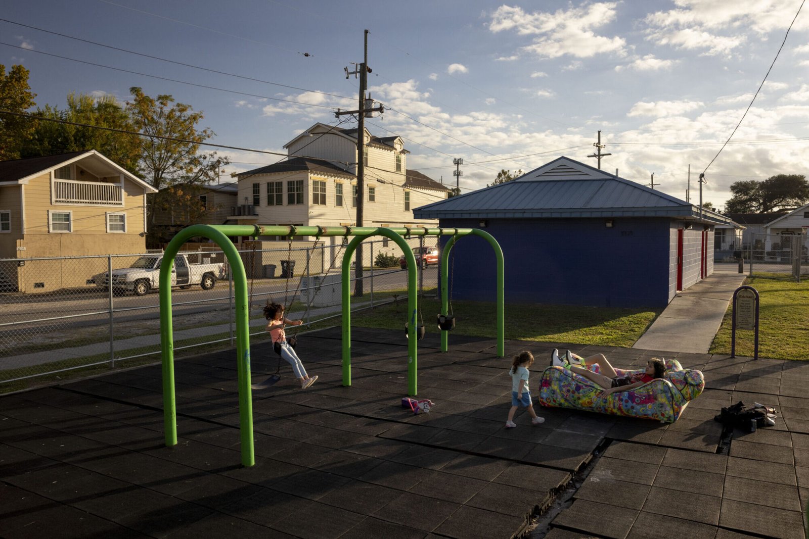A child plays on swings in a playground