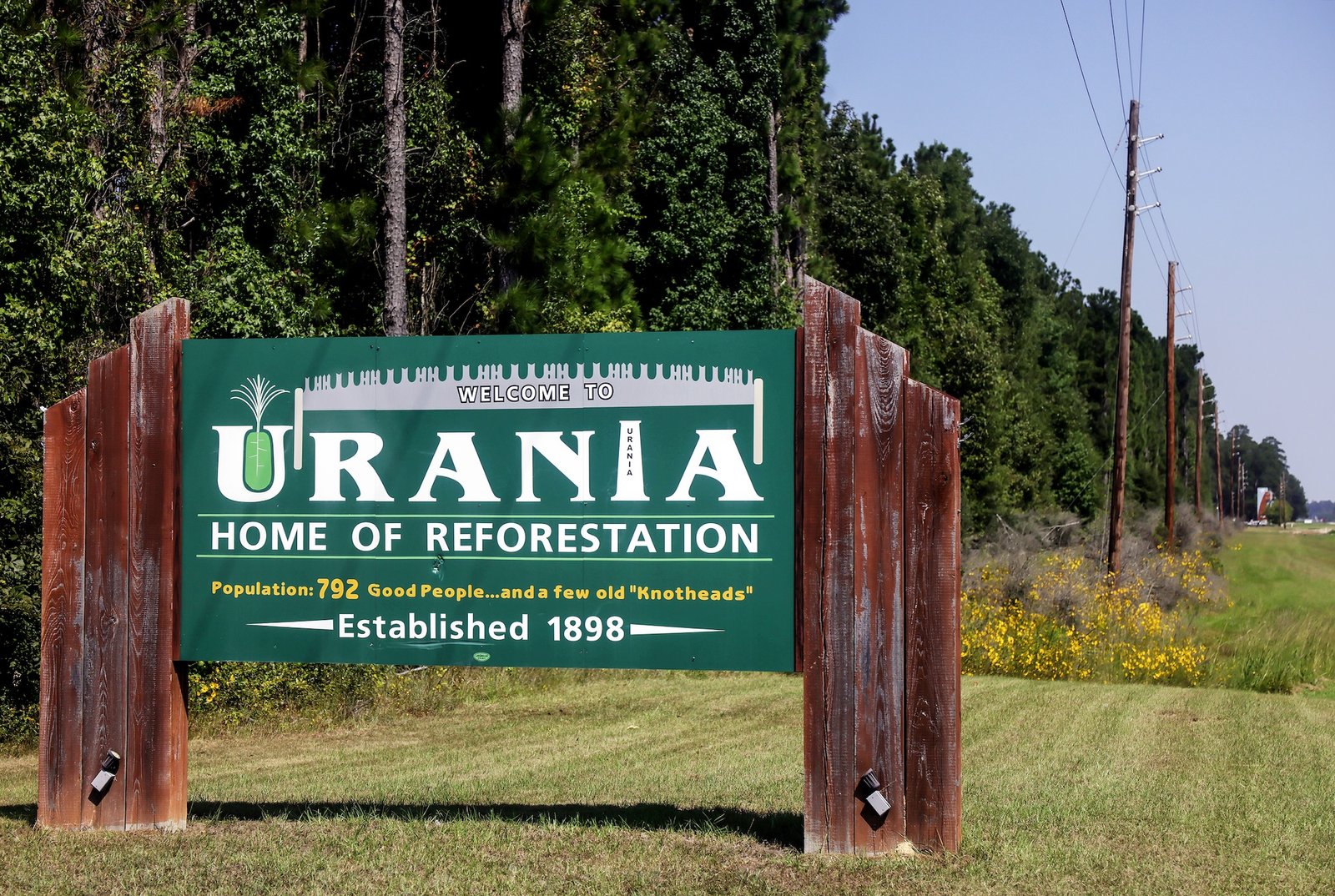 A sign says 'urania, home of reforestation'