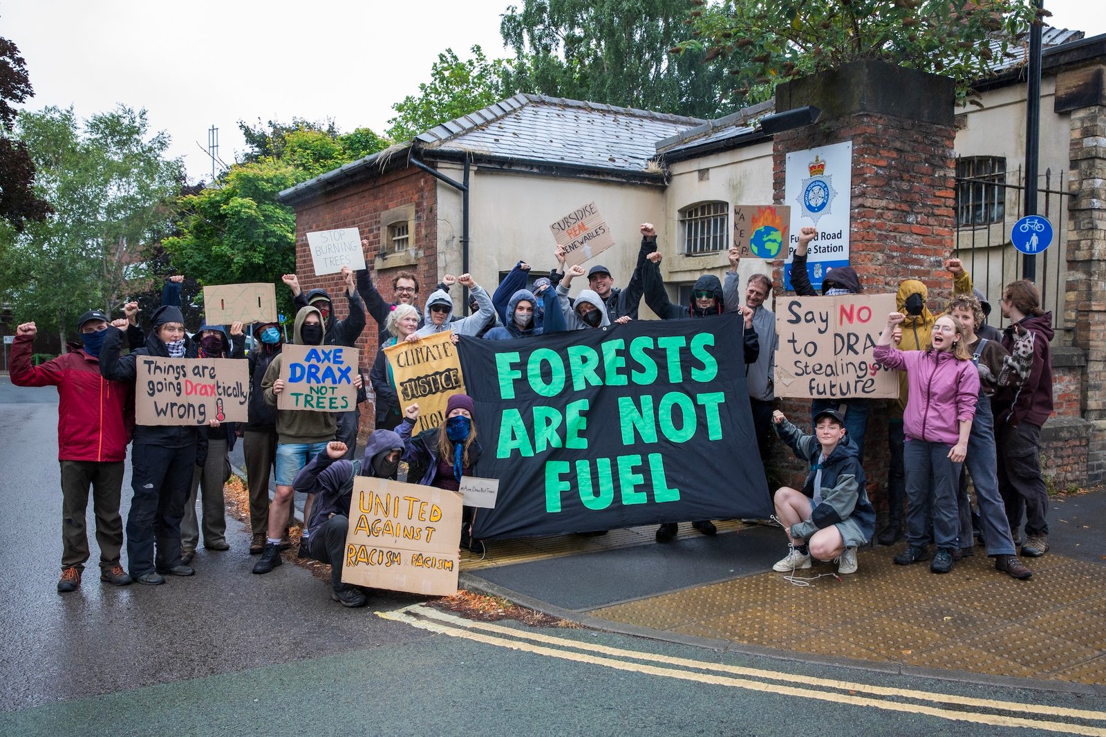 protesters with signs against drax