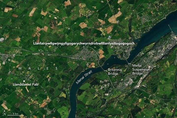 The long-named town in Wales appears as a gray patch amidst a bucolic image with green farmland bordering the Menai Strait. Two bridges mark an area known for treacherous whirlpools.