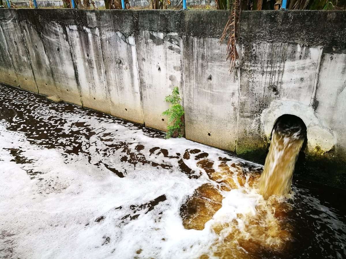 Water pouring from a sewage outflow pipe into a river