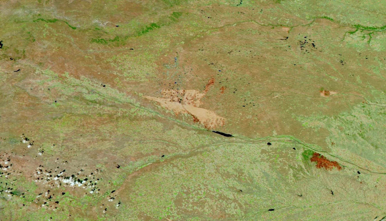 A burned area on the plains of western Nebraska appears as a large tan area in a false-color satellite image.