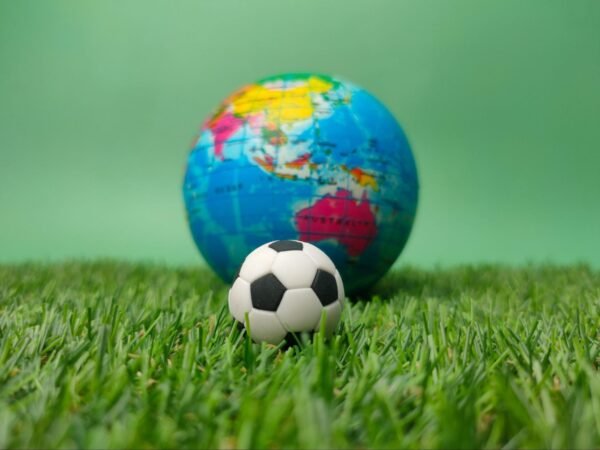 a soccer ball next to a globe of the planet