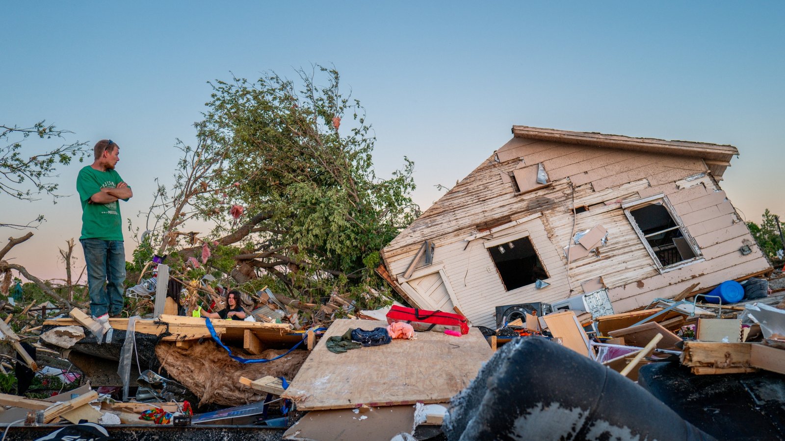 The Crowder family surveys their home destroyed by a tornado on May 07, 2024 in Barnsdall, northeast Oklahoma. The EF3 twister that struck claimed one life and destroyed dozens of homes in the community of just over 1,000 people. (Photo by Brandon Bell/Getty Images)
