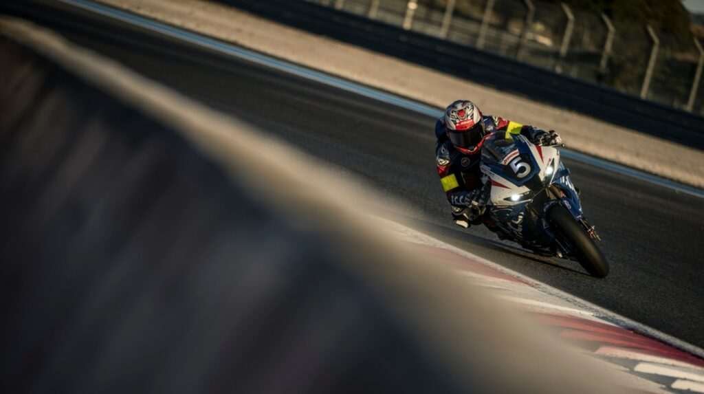 A motorcycle and rider race around a bend at a track during an event at the FIM Endurance World Championship.