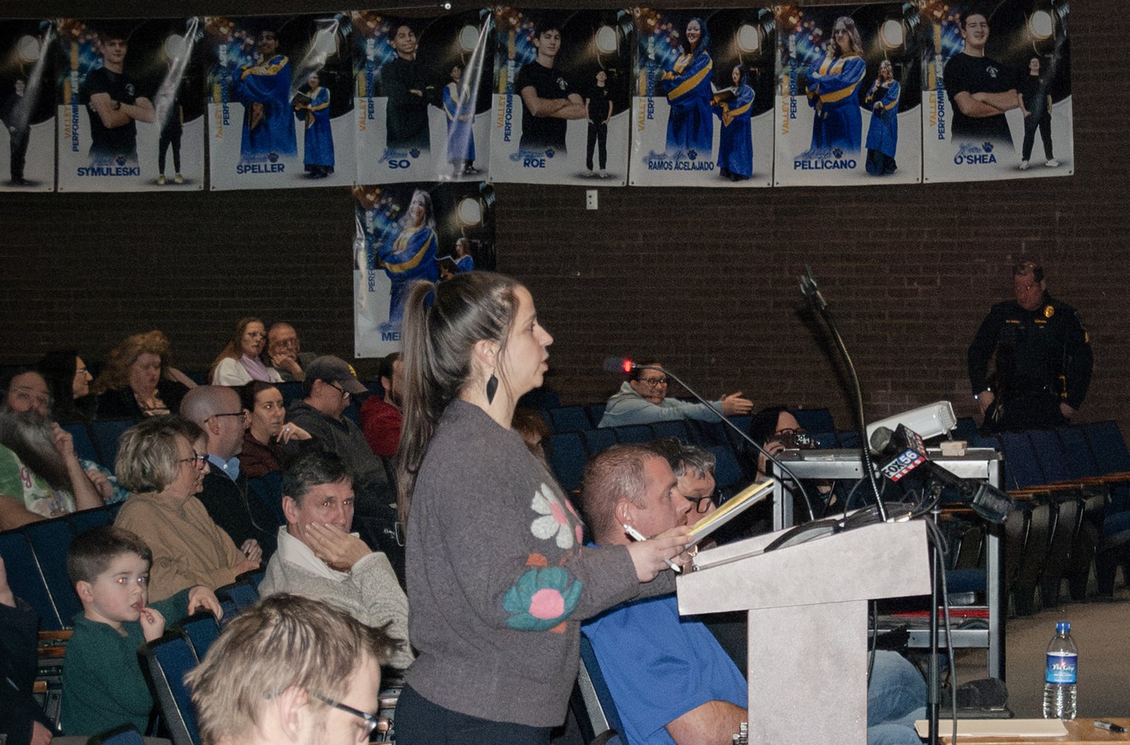 Tamara Misewicz-Healey speaks at a podium in an auditorium full of people.