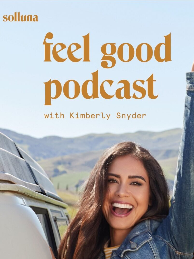 A woman in a denim jacket smiles and raises a peace sign next to a van in a scenic landscape. Text reads "feel good podcast with Kimberly Snyder" and "podcastone" at the bottom.