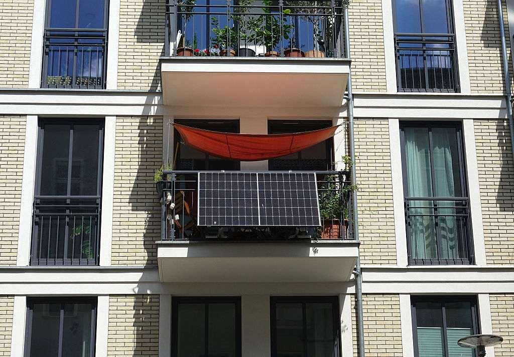 An apartment building with solar panels attached to a balcony