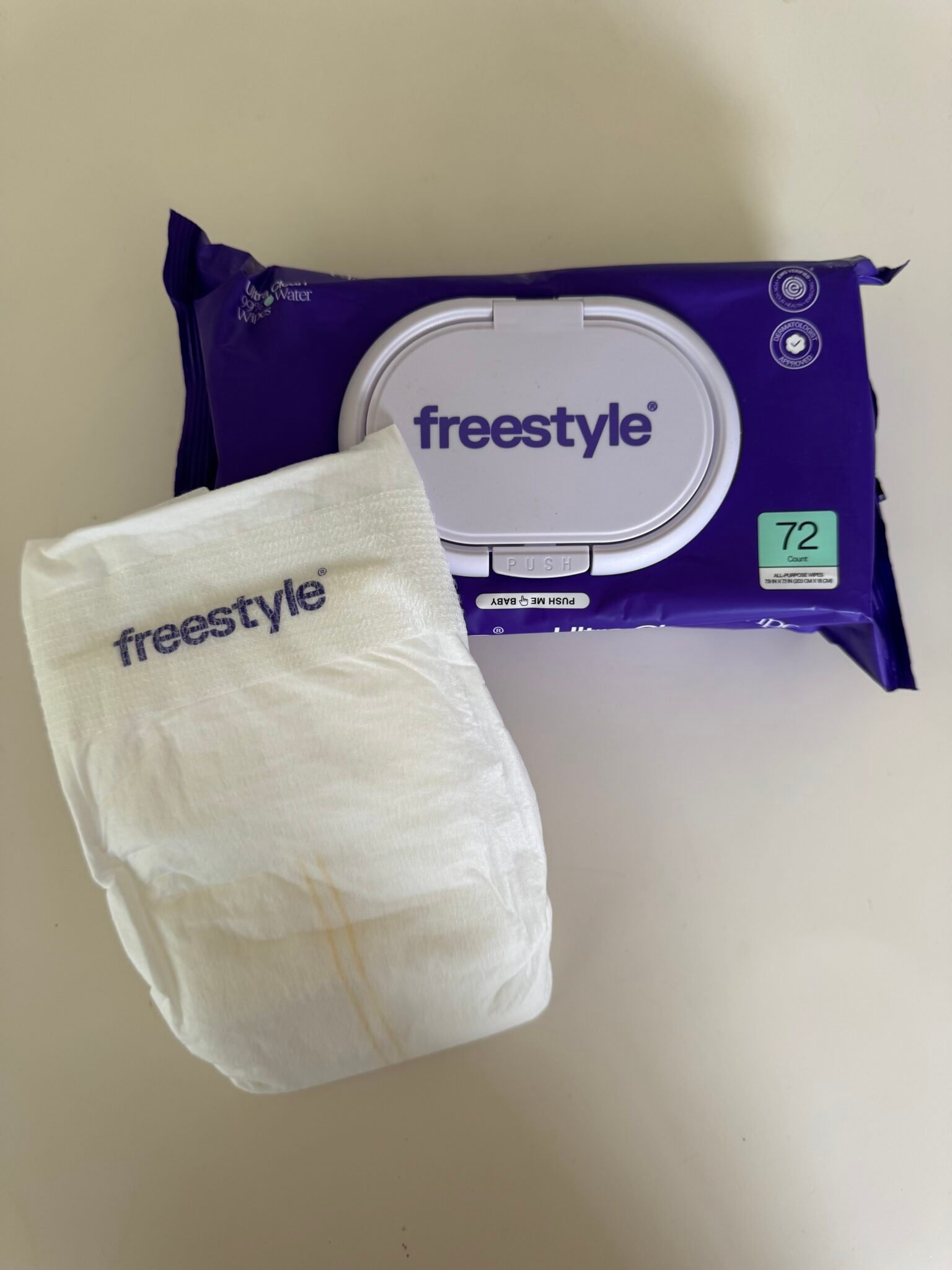 A pack of Freestyle baby wipes and a single wipe with the Freestyle logo placed on a white surface.