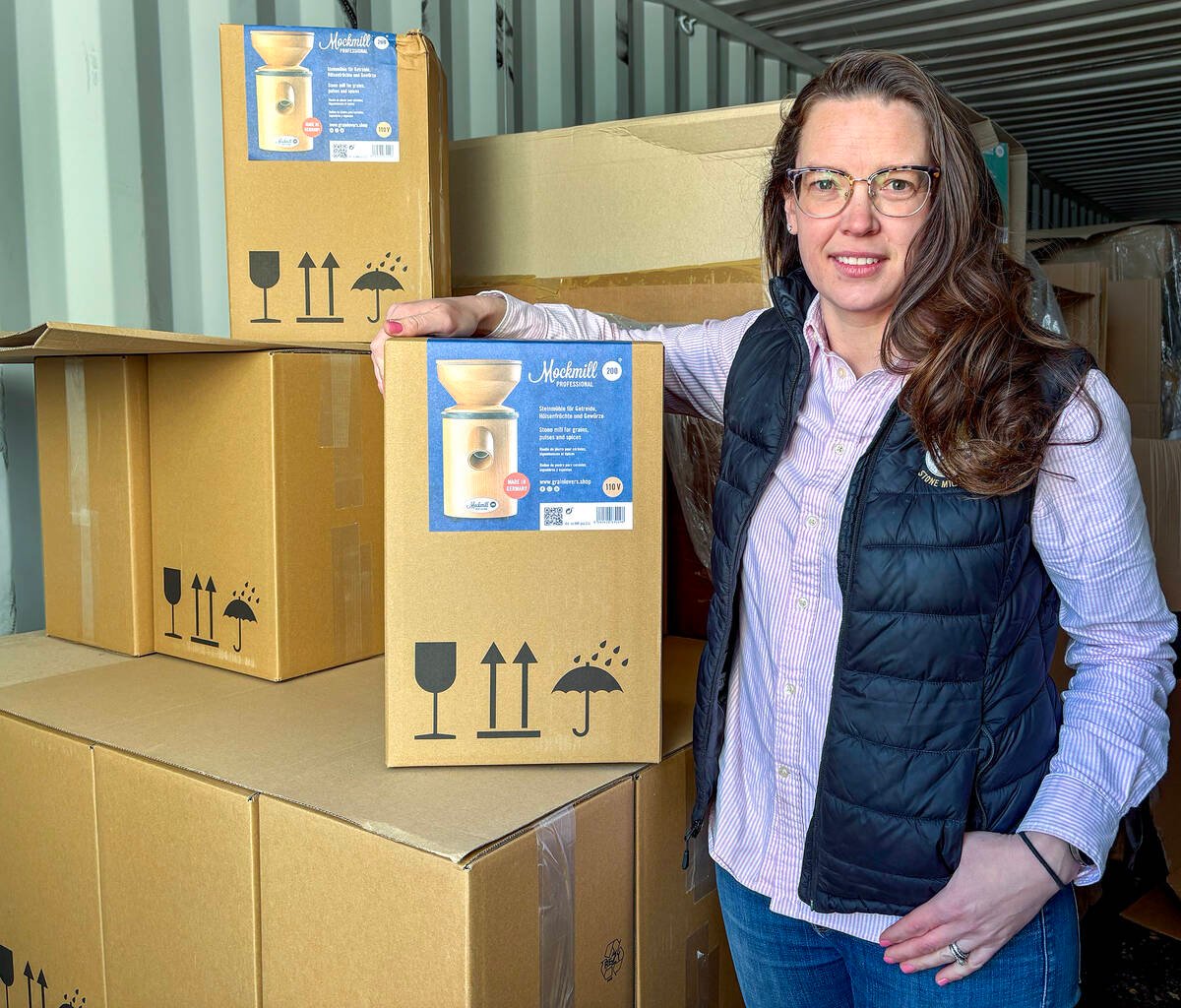 Melissa McKeown, co-owner of 1847 Stone Milling, stands beside boxes of Mockmill, a popular home-sized stone mill. Photo: Diana Martin.