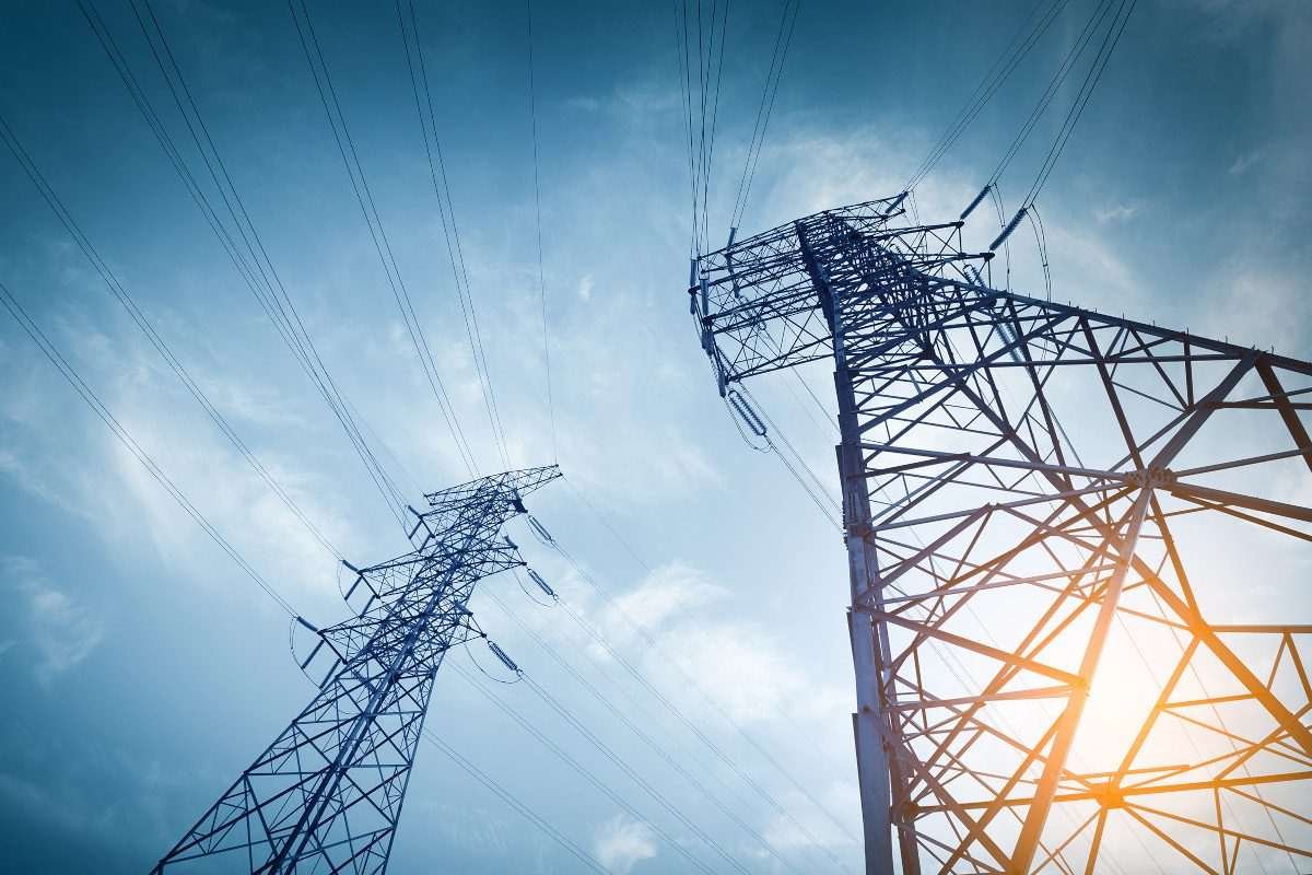 Electrical pylons, seen from below, with backdrop of troubled, cloudy sky overhead