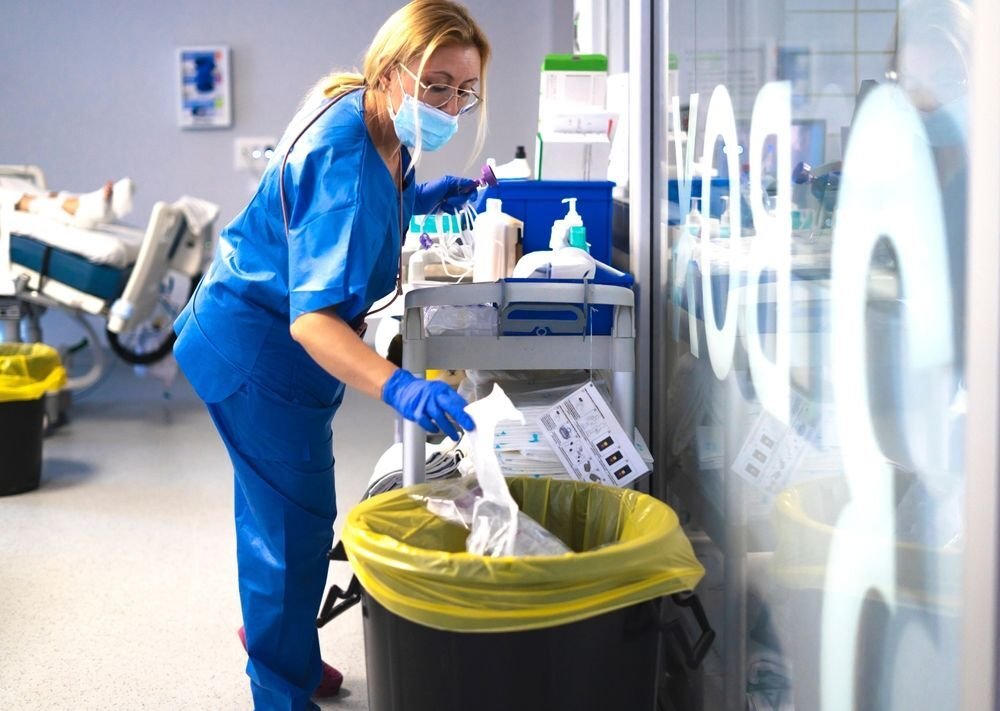 A clinician discarding medical waste.