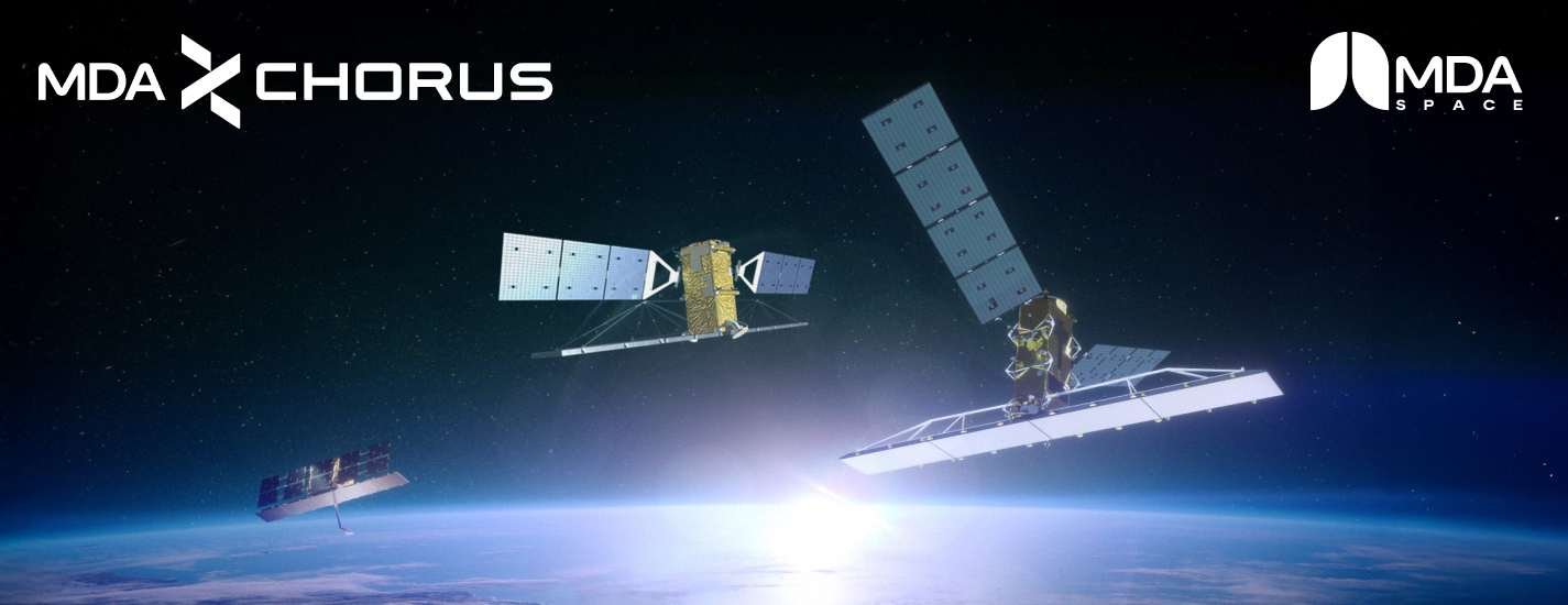 An artistic rendering of the MDA Space CHORUS-C (right), RADARSAT-2 (centre), and CHORUS -X (left) synthetic aperture radar (SAR) Earth observation constellation in orbit above Earth. RADARSAT-2 was launched in 2007, with CHORUS - C/X satellites planned for Q4 2026 launch. The SAR imaging satellites fly in formation over the planet’s curved horizon at sunrise. Each satellite features large deployable solar arrays and a broad radar antenna structure used to capture high-resolution imagery of Earth’s surface day or night and through cloud cover. The scene emphasizes the three-satellite SAR mission architecture, showing the satellites positioned to deliver coordinated CHORUS-C and RADARSAT-2 wide-area monitoring, with following CHORUS-X high-resolution imaging.