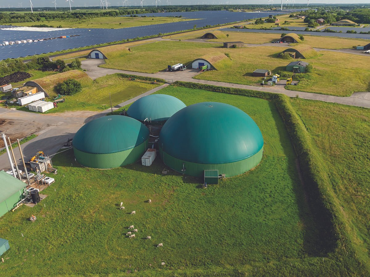 Aerial view of biogas domes on a flat green landscape
