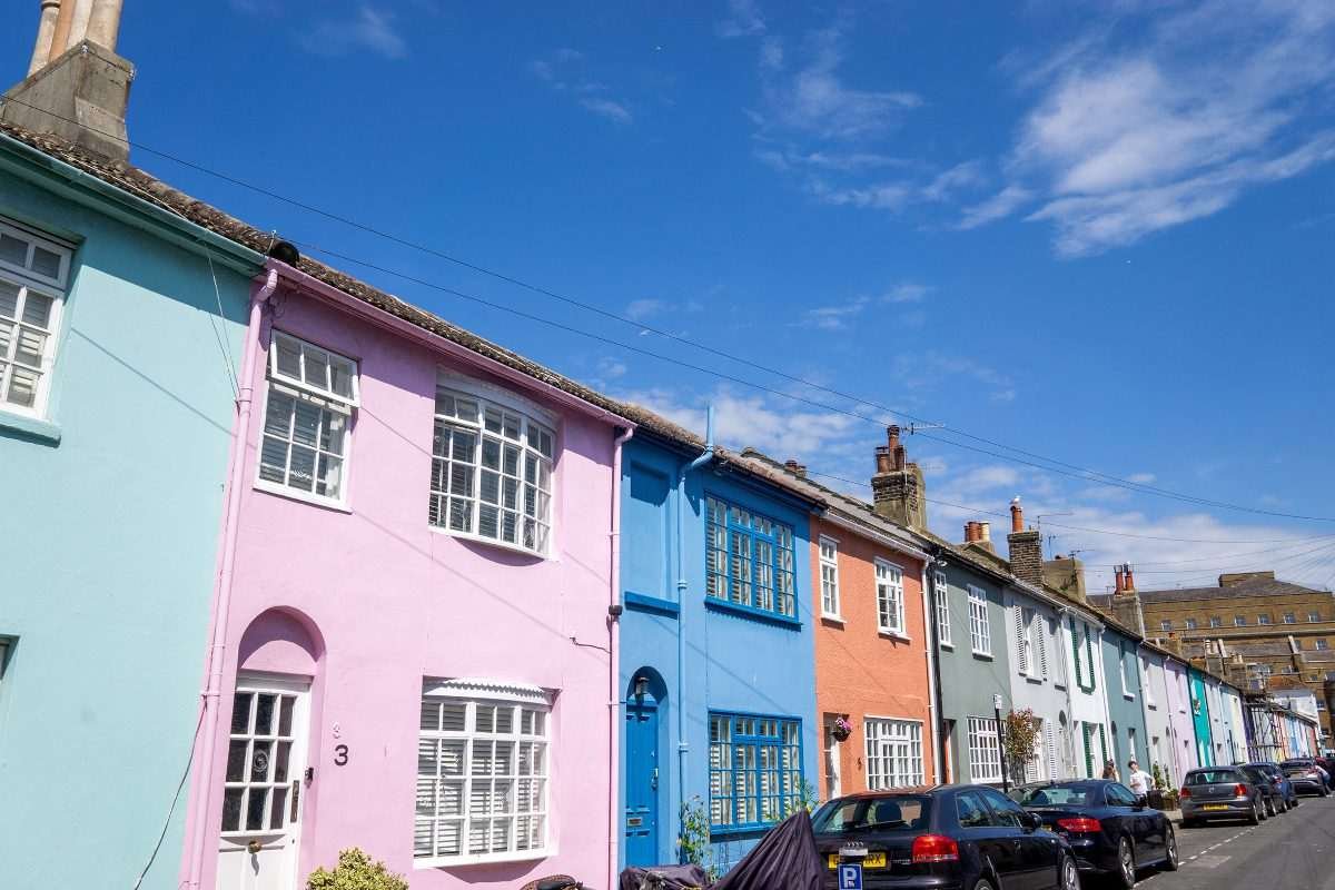 Row of brightly coloured terraced houses in Brighton under a blue sky