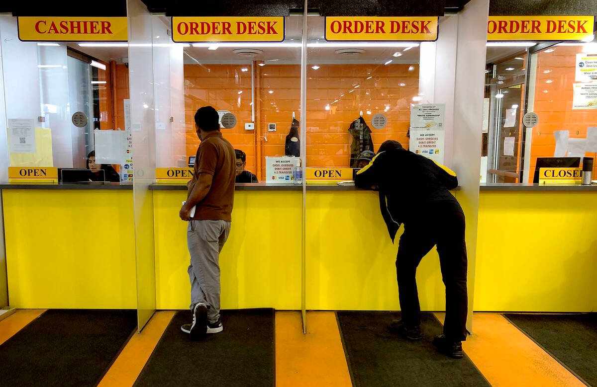 Two people place orders with a wholesaler at the Ontario Food Terminal, where approximately 5.6 million pounds of food changes hands daily. Photo: Diana Martin