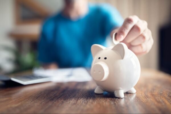 a person putting a coin into a piggybank