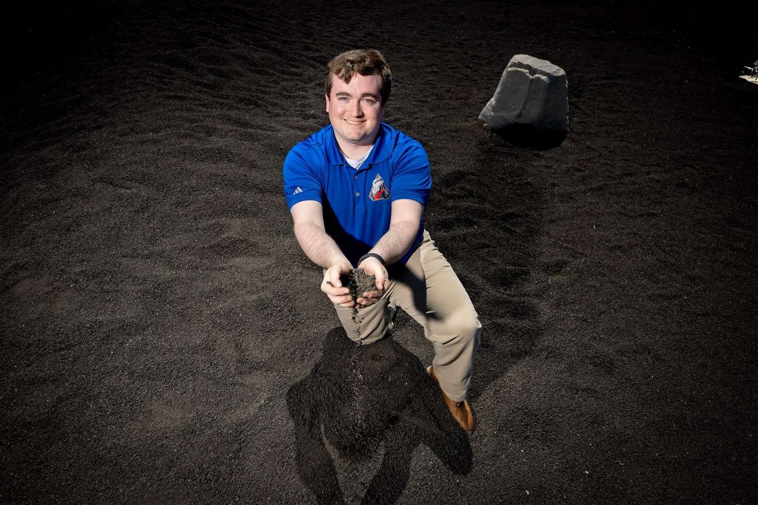 NASA’s Daniel Stubbs, seen here at the Lunar Regolith Terrain field at Marshall Space Flight Center, used his experience as a graduate student at in aerospace engineering at Auburn University modeling lunar regolith plumes into a position with NASA Marshall’s Plume and Aero Environments team working to characterize interactions between clouds of lunar regolith and commercial human landing systems.
