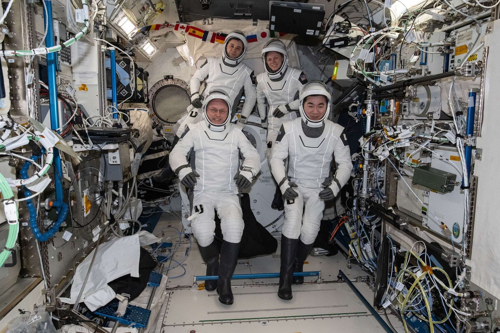 NASA's SpaceX Crew-11 astronauts gather together for a crew portrait wearing their Dragon pressure suits during a suit verification check inside the International Space Station's Kibo laboratory module. Clockwise from bottom left are, NASA astronaut Mike Fincke, Roscosmos cosmonaut Oleg Platonov, NASA astronaut Zena Cardman, and JAXA (Japan Aerospace Exploration Agency) astronaut Kimiya Yui.