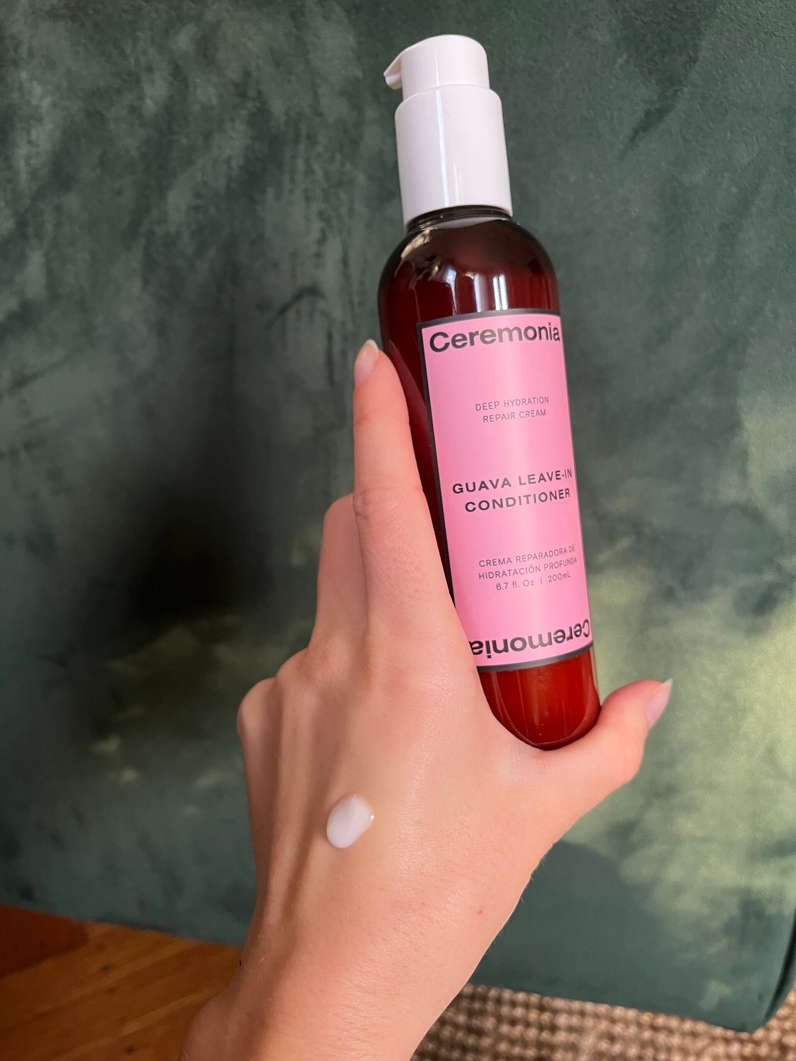 A hand holding Ceremonia Leave-In Conditioner