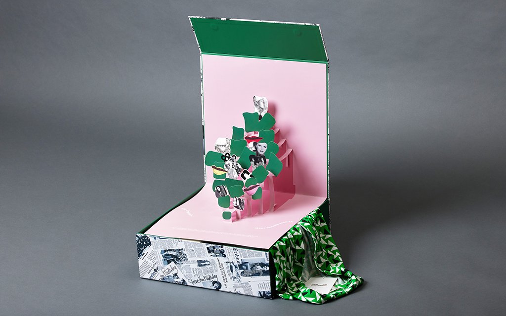 Diane von Furstenberg anniversary PR packaging featuring a bookstyle rigid box with a layered pop-up paper display.