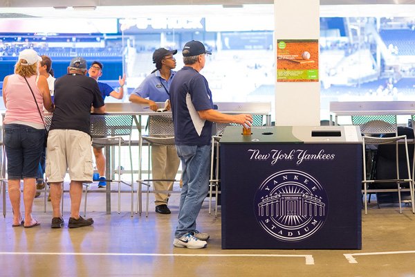 A bottle being recycled in a Yankees trash and recycling bin