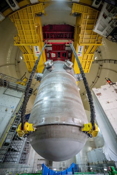 Viewed from below, the reactor pressure vessel is suspended by lifting gear beneath the yellow polar crane inside Hinkley Point C's Unit 2 reactor building