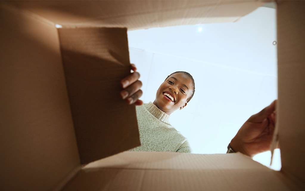 A customer unboxing a D2C ecommerce shipping box.