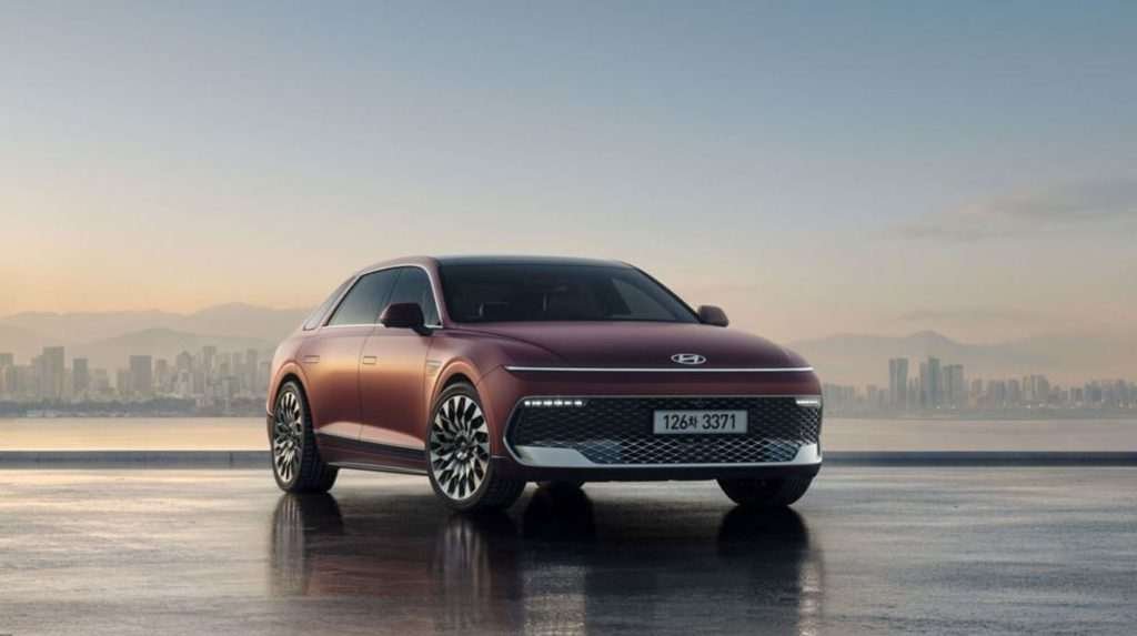The Hyundai New Grandeur SUV parked on a rooftop in front of a city background.