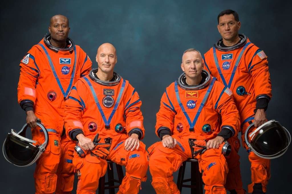 Current image: La tripulación de Artemis III posa para una foto oficial en sus trajes espaciales naranjas (de izquierda a derecha: Andre Douglas, Luca Parmitano, Randy Bresnik y Frank Rubio).