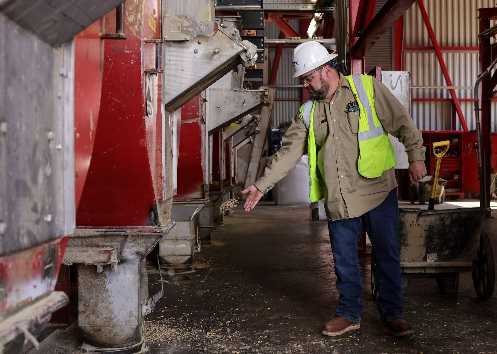 The manager of Drax’s wood pellet mill tosses a few pellets while inspecting machinery